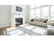 Bright living room featuring a fireplace, large windows, and a blue patterned rug at 5351 Rose Dr, Zionsville, IN 46077