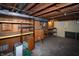 Unfinished basement with exposed ceiling, concrete floor, and built in wood shelving and cabinets at 5803 Schoolwood Dr, Speedway, IN 46224
