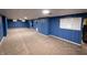Finished basement featuring blue paneled walls, neutral carpet flooring, and natural light at 5803 Schoolwood Dr, Speedway, IN 46224