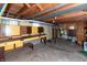 Unfinished basement with yellow walls, exposed ceiling, concrete floor, and built in cabinet and work bench at 5803 Schoolwood Dr, Speedway, IN 46224