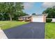 A lovely single story brick home with a long driveway and an attached garage, with trees at 5803 Schoolwood Dr, Speedway, IN 46224