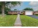 Charming brick ranch home with a well-manicured lawn and a two-car attached garage at 5803 Schoolwood Dr, Speedway, IN 46224
