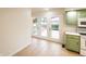 Bright and airy eat-in kitchen with green cabinets and views to a walkout deck and back yard at 5803 Schoolwood Dr, Speedway, IN 46224