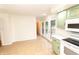 Open concept kitchen with green cabinets leads to a deck and a hallway to the bedrooms at 5803 Schoolwood Dr, Speedway, IN 46224