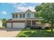 Two-story home with a two-car garage, brick accents, a well-manicured lawn, and a charming front porch at 6045 Copeland Mills Ct, Indianapolis, IN 46221