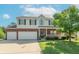 Two-story home with a two-car garage, brick accents, a well-manicured lawn, and a charming front porch at 6045 Copeland Mills Ct, Indianapolis, IN 46221