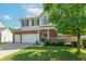 Two-story home featuring brick and siding, manicured lawn, and an attached three car garage at 6045 Copeland Mills Ct, Indianapolis, IN 46221