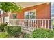 Inviting front porch with red brick, white railings, and manicured bushes and flowers at 6045 Copeland Mills Ct, Indianapolis, IN 46221