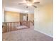 Hallway features neutral carpet, railing overlooking the front door and an overhead ceiling fan at 6045 Copeland Mills Ct, Indianapolis, IN 46221