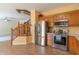Kitchen featuring stainless steel appliances, warm wood cabinetry, and tile flooring at 6045 Copeland Mills Ct, Indianapolis, IN 46221