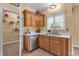 Kitchen area with wooden cabinets, stainless steel dishwasher, and a view into the pantry at 6045 Copeland Mills Ct, Indianapolis, IN 46221