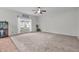 Spacious living room featuring neutral carpet, bright window, ceiling fan, and decorative accents at 6045 Copeland Mills Ct, Indianapolis, IN 46221