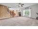 Cozy living room with plush carpeting, a ceiling fan, and staircase access to the upper level at 6045 Copeland Mills Ct, Indianapolis, IN 46221