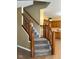 Carpeted staircase with wood railing offers access to upper level from eat-in kitchen at 6045 Copeland Mills Ct, Indianapolis, IN 46221