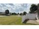 Backyard view showcasing a patio, white fence, and manicured lawn with neighborhood views at 6139 Robinwood Dr, Indianapolis, IN 46237
