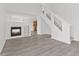 Bright living room featuring sleek gray flooring, a modern fireplace, and staircase at 618 Stobus Dr, Greenwood, IN 46143