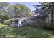 Backyard view of home with light blue siding, sunroom, green lawn, and mature trees at 6637 E County Road 600 S, Plainfield, IN 46168
