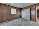 This bedroom features classic wood paneling, neutral carpet and closet at 6637 E County Road 600 S, Plainfield, IN 46168