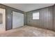 Bedroom with window, wall paneling, carpet, baseboard heater, and a spacious closet at 6637 E County Road 600 S, Plainfield, IN 46168