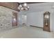 Open living room with stone accent wall, wood beams, rustic chandelier, and adjacent grandfather clock at 6637 E County Road 600 S, Plainfield, IN 46168