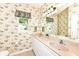 Bathroom featuring double sinks, floral wallpaper, and a window at 6656 Easy St, Fishers, IN 46038