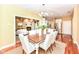 Bright dining area features wood floors,stylish chandelier, wood table, seating for six and opens to the living room at 6656 Easy St, Fishers, IN 46038