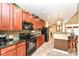 Kitchen with black appliances, granite countertops, wood cabinetry, and tile backsplash at 6656 Easy St, Fishers, IN 46038