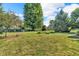 A large backyard featuring mature trees, green grass, and a partially visible fence line at 6686 Woodcrest Dr, Avon, IN 46123