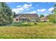 A well-maintained backyard featuring a brick home with a screened-in porch and expansive grassy area at 6686 Woodcrest Dr, Avon, IN 46123