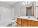 Bright bathroom with tub, toilet, wood-look vanity, and neutral tile floor at 6686 Woodcrest Dr, Avon, IN 46123