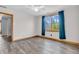 Bright bedroom with hardwood floors, ceiling fan, and window with blue curtains at 6686 Woodcrest Dr, Avon, IN 46123