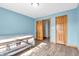 Bright bedroom with wood laminate flooring, blue walls, and natural wood trim at 6686 Woodcrest Dr, Avon, IN 46123