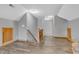 Bright hallway with laminate floors, a staircase with wooden railings, and neutral paint at 6686 Woodcrest Dr, Avon, IN 46123
