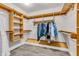 Spacious walk-in closet with wooden shelving and hanging rods for organized storage at 6686 Woodcrest Dr, Avon, IN 46123