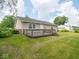 A well-maintained backyard shows a wooden deck adjacent to the house, perfect for outdoor entertaining at 7645 Inverness Dr, Indianapolis, IN 46237