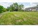 Large backyard with a spacious lawn, mature trees, and a wooden deck, ideal for outdoor enjoyment at 7645 Inverness Dr, Indianapolis, IN 46237