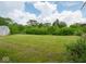 A lush, green backyard is surrounded by mature trees, offering a private and peaceful outdoor space at 7645 Inverness Dr, Indianapolis, IN 46237