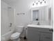 A well-lit bathroom features a tub-shower, toilet, and gray vanity with a sink and mirrored medicine cabinet at 7645 Inverness Dr, Indianapolis, IN 46237