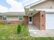 Exterior detail of the home, showcasing the brick, vinyl siding, and well-maintained landscaping at 7645 Inverness Dr, Indianapolis, IN 46237