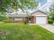 Charming single-story home with a brick facade, attached garage, and well-maintained front lawn at 7645 Inverness Dr, Indianapolis, IN 46237