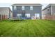A spacious backyard with well-maintained lawn, trampoline, blue chairs, playhouse and privacy fence at 77 Winding Brook Way, Pendleton, IN 46064