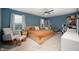 Serene bedroom with a queen-sized bed, sitting area, large windows, and a bookcase at 77 Winding Brook Way, Pendleton, IN 46064