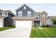 Two-story home showcasing a blue-and-brick exterior, a two-car garage, and a well-manicured front lawn at 77 Winding Brook Way, Pendleton, IN 46064