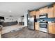 Open kitchen with stainless steel appliances, maple cabinets, and seamless flow to living and dining areas at 77 Winding Brook Way, Pendleton, IN 46064