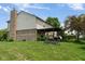 Exterior view of the backyard with covered patio, brick chimney and mature landscaping at 787 West St, Whiteland, IN 46184