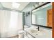 Well-lit bathroom with a skylight, modern vanity, and a shower with a white curtain at 787 West St, Whiteland, IN 46184