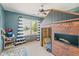 The unique house-shaped bed is the highlight of this ' room, complemented by a ceiling fan and bright window at 787 West St, Whiteland, IN 46184