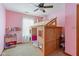 This bedroom features pink walls and a creative, wooden, house-shaped bunk bed with a ceiling fan overhead at 787 West St, Whiteland, IN 46184