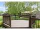 View of wood deck and backyard featuring mature landscaping with a weeping willow tree at 787 West St, Whiteland, IN 46184