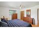 Cozy bedroom featuring wood furniture, a ceiling fan, and a window with natural light at 8219 Bishops Ln, Indianapolis, IN 46217
